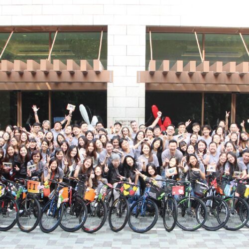 Corporate team working together to build bikes for a good cause and then show casing their proud finished product!